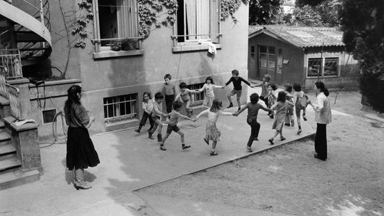 Enfants faisant la ronde dans la cour de récréation de leur école en France ©Getty - Pierre Michaud 